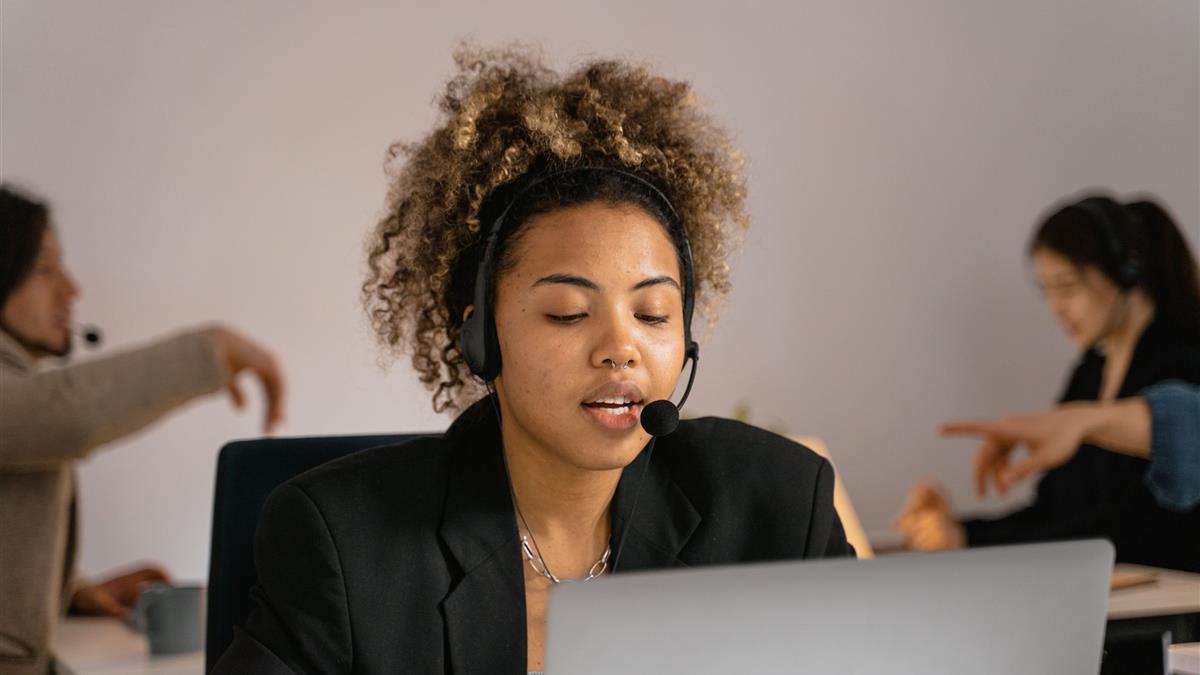 Professionnelle suivant une formation en ligne en direct, casque et ordinateur portable
